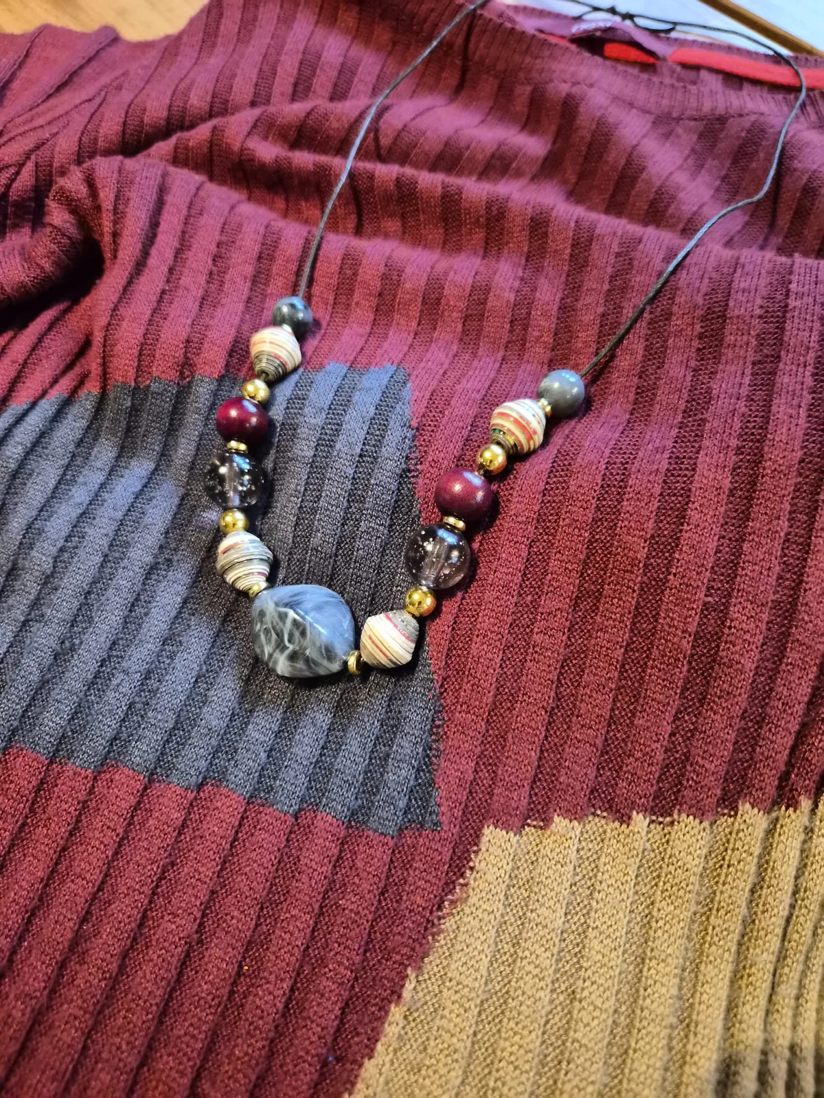 The first finished necklace interpretation arranged on the wine-coloured dress